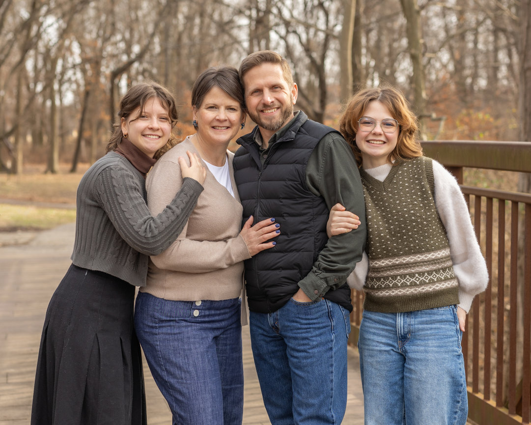 Family posing on wooden bridge in park