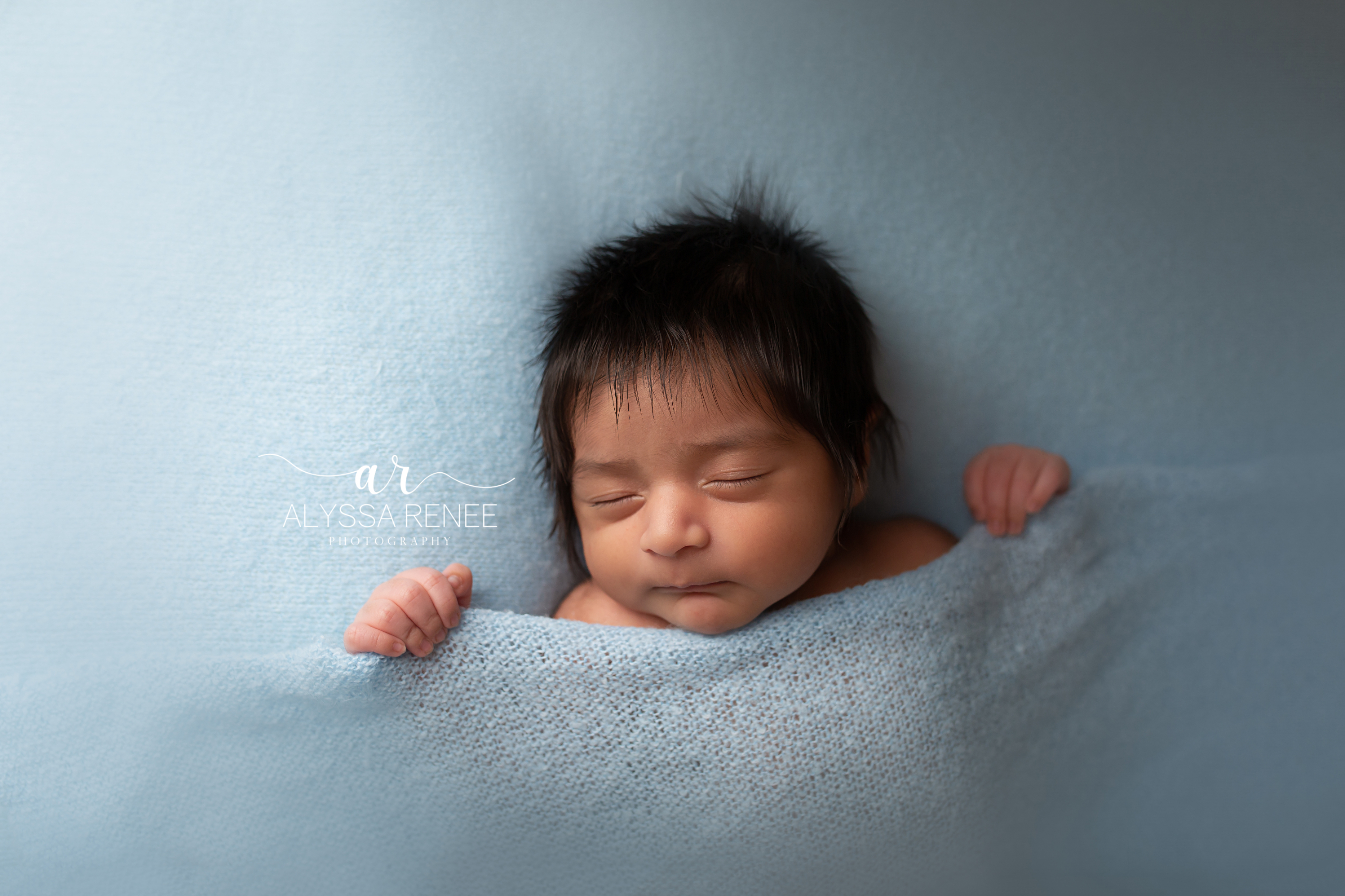 Baby pulling up covers in this artistic newborn portrait in our St Johns county studio