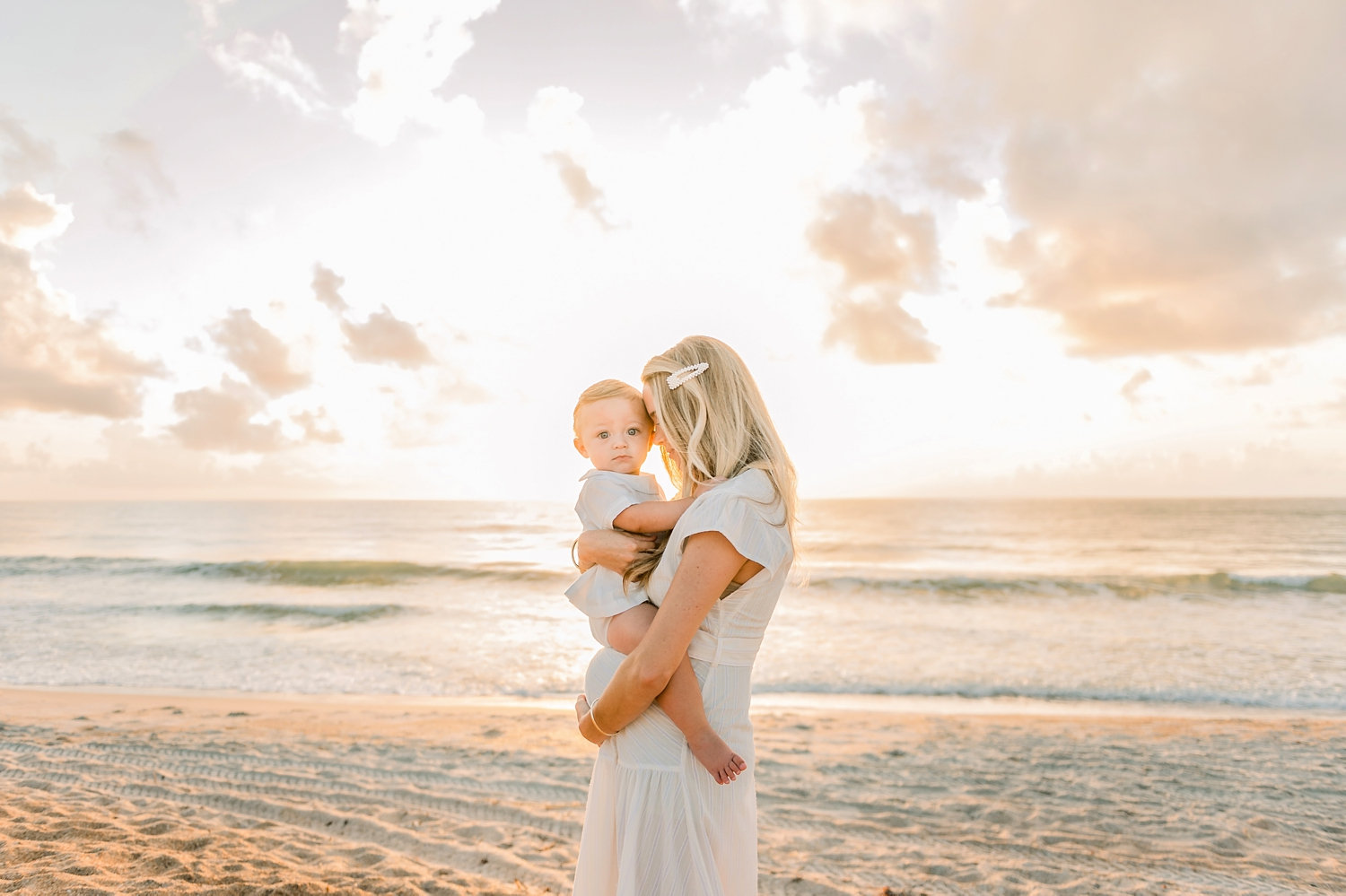 one year old boy sitting on pregnant mama's belly, beach family portrait session