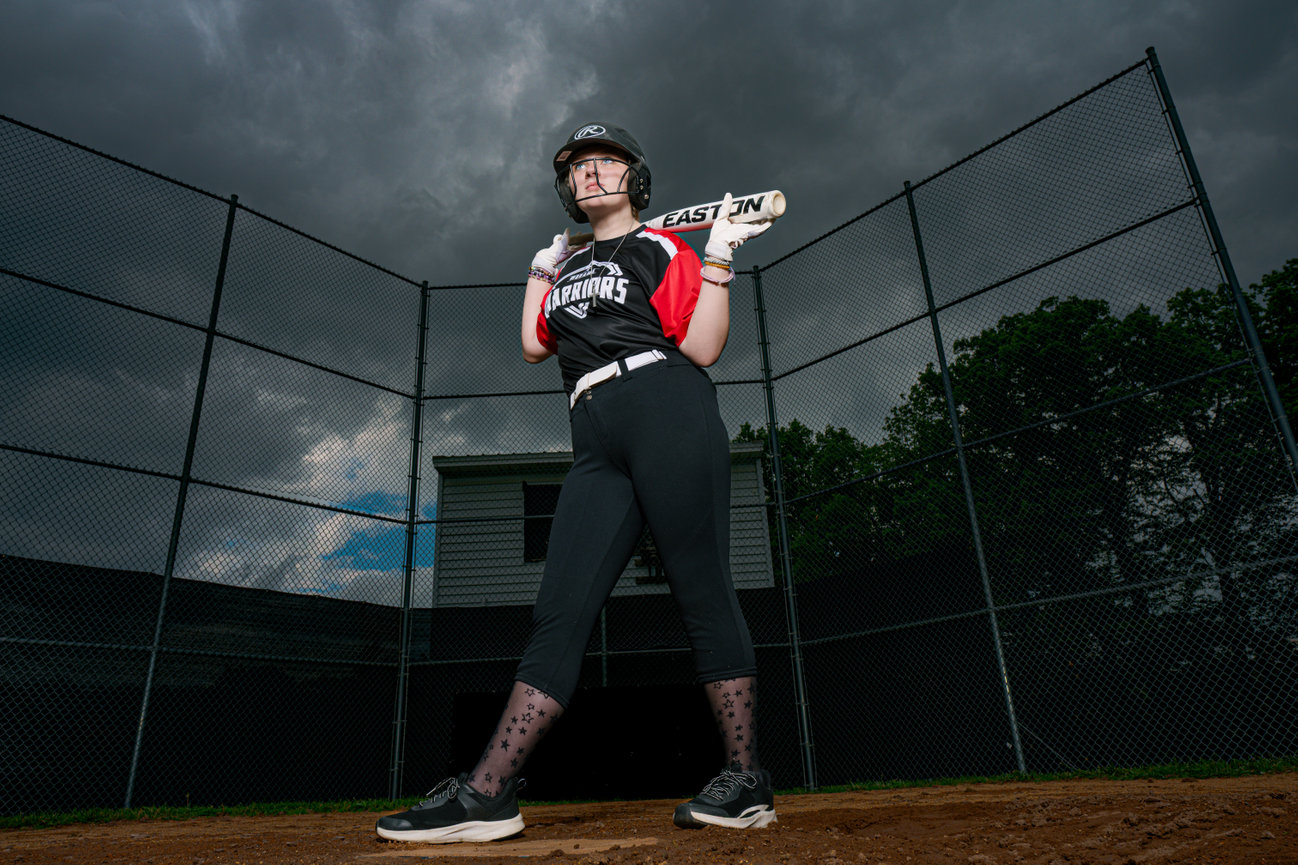 softball player holding bat across her shoulders