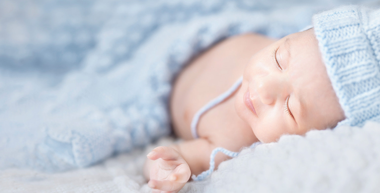 Sleeping baby portrait in a softly lit bedroom setting, capturing a calm and intimate in-home moment