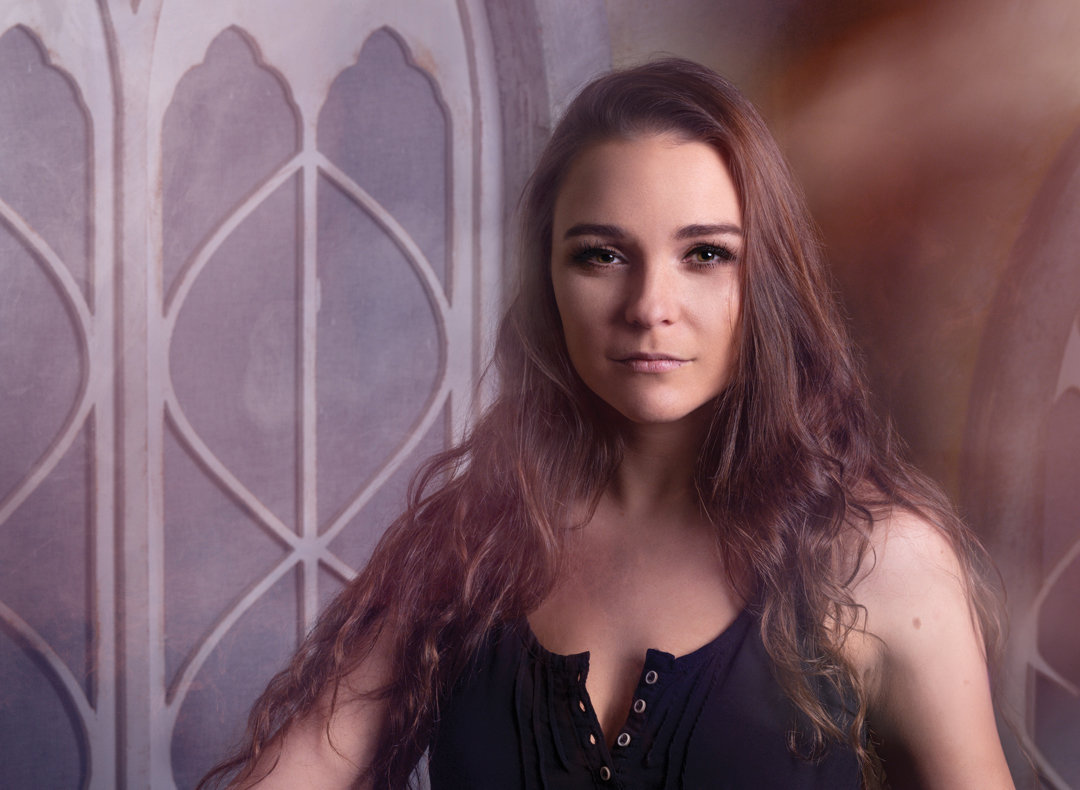 Indoor portrait of a young woman in Carmel, Indiana with soft, dreamy studio lighting, confident expression, and a refined fine art feel highlighting natural beauty