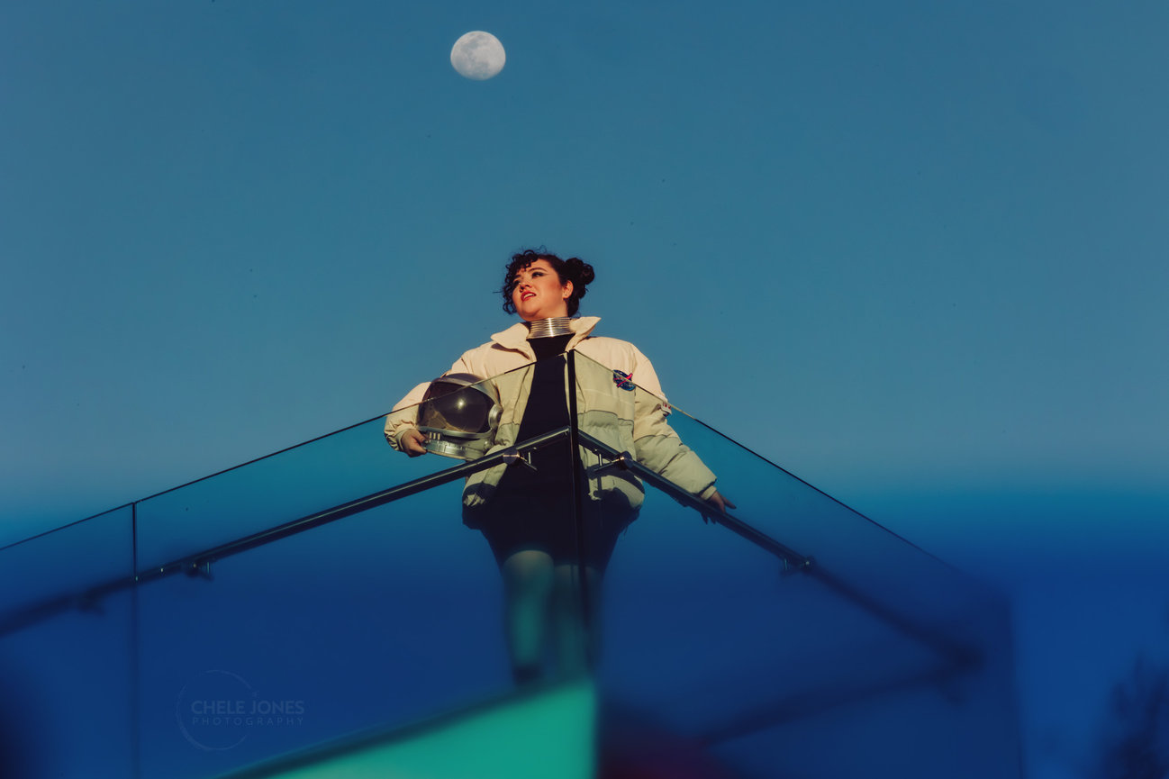A Rancho Santa Margarita senior who wanted a space themed senior session stands under the moon in Newport Beach, CA. by Chele Jones, OC senior portrait photographer.