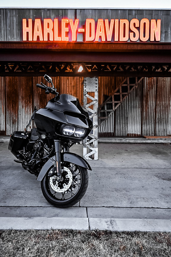 Black Harley-Davidson motorcycle parked under a glowing Harley-Davidson sign at Summit Harley-Davidson in Vineyard, Utah. Captured by Tre Nelson Photo.