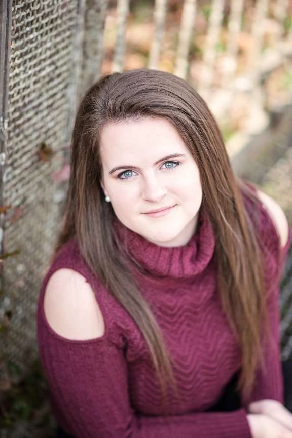 senior girl sitting at Dogwood Canyon posing for portrait