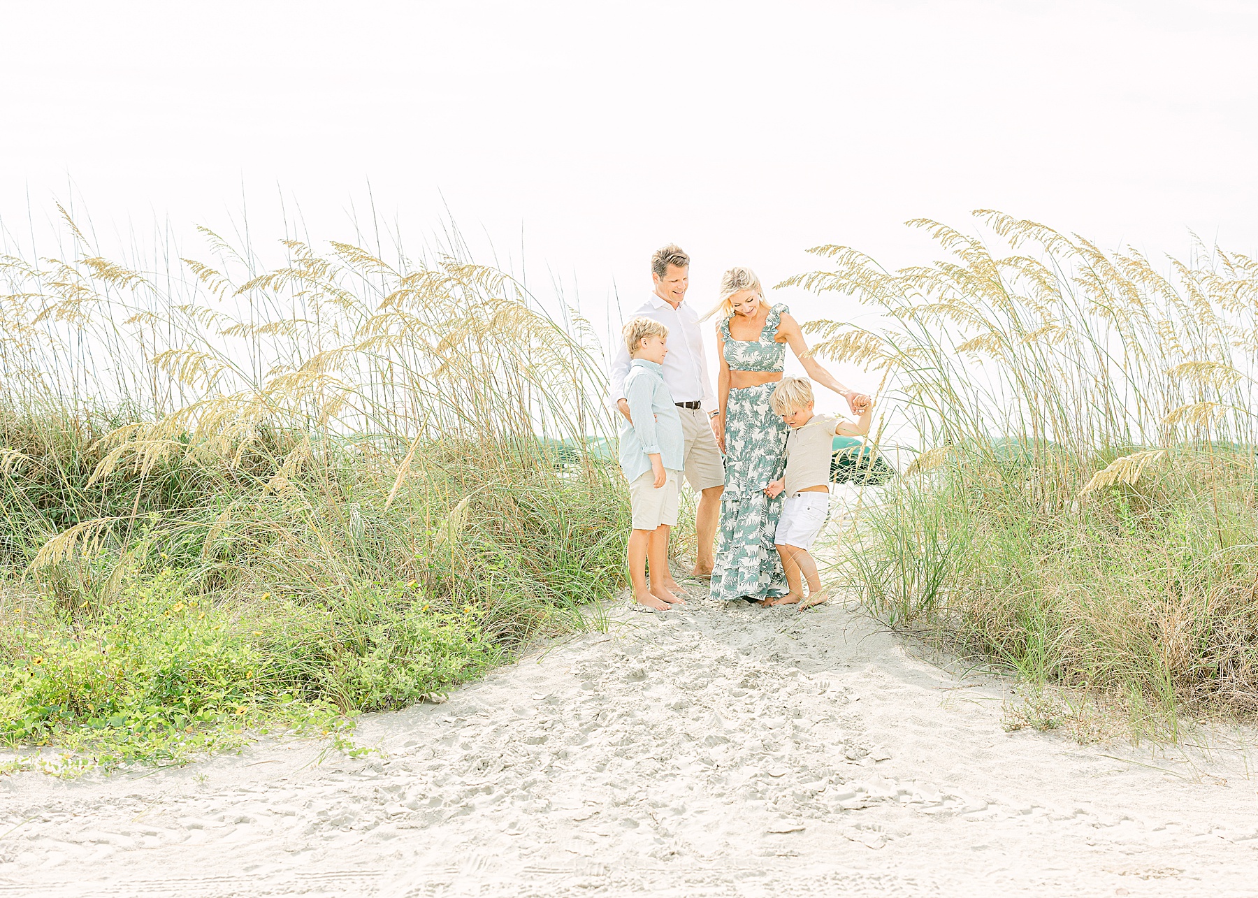 family holding hands near the coast at the cloister on sea island wearing neutral colors