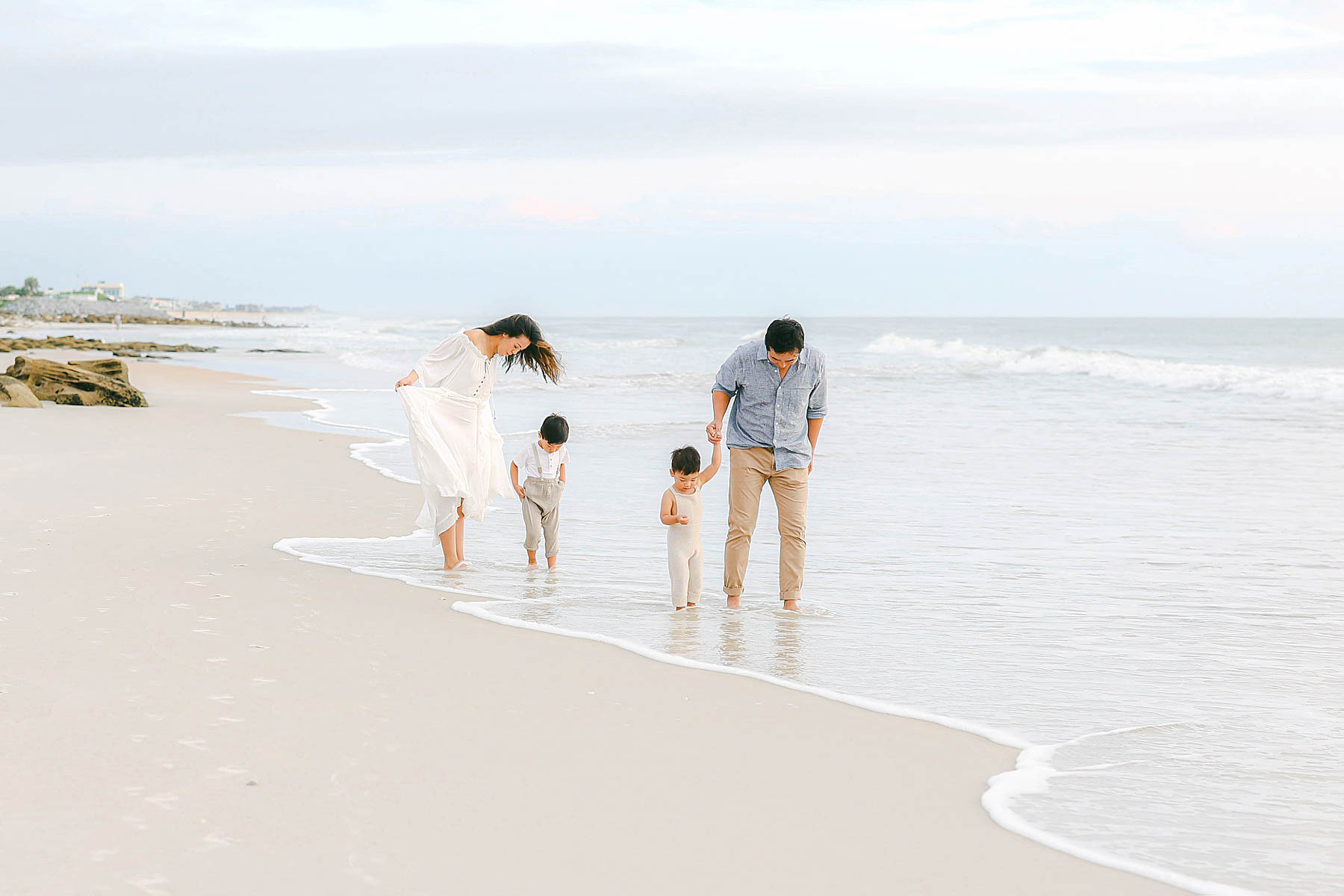 family walking in neutral colors on the beach