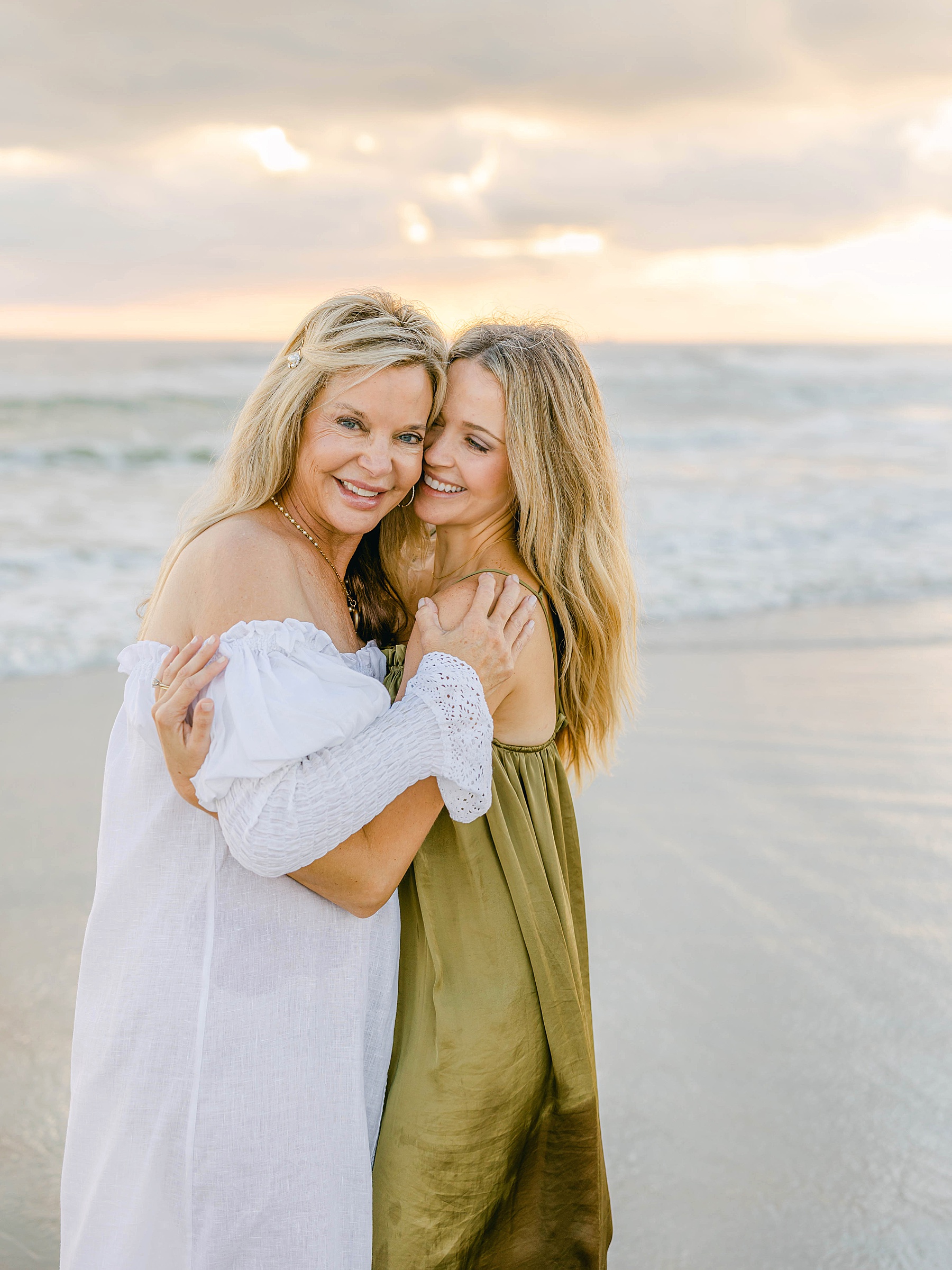 women hugging beach in the water at sunrise on the beach