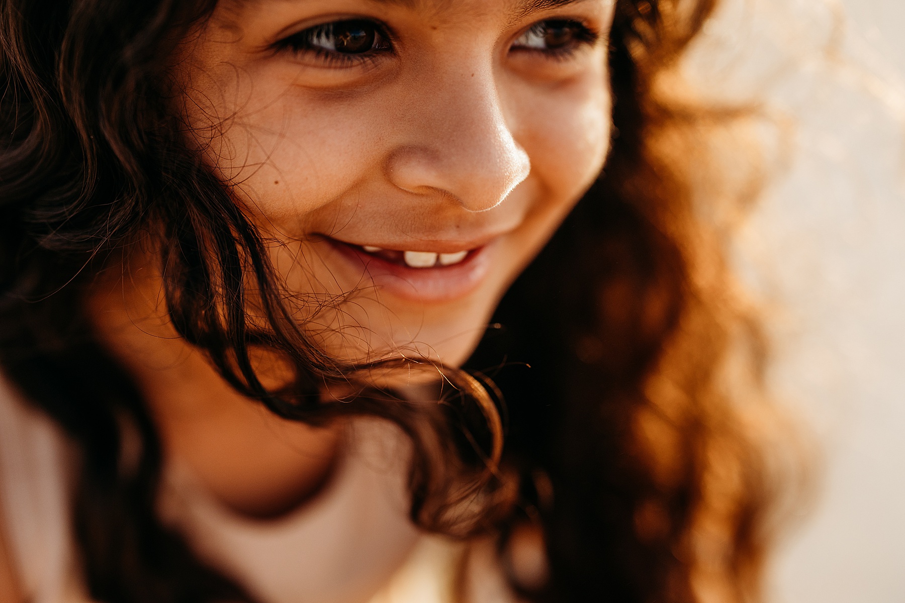 close up of little girl at sunrise on the beach in golden light