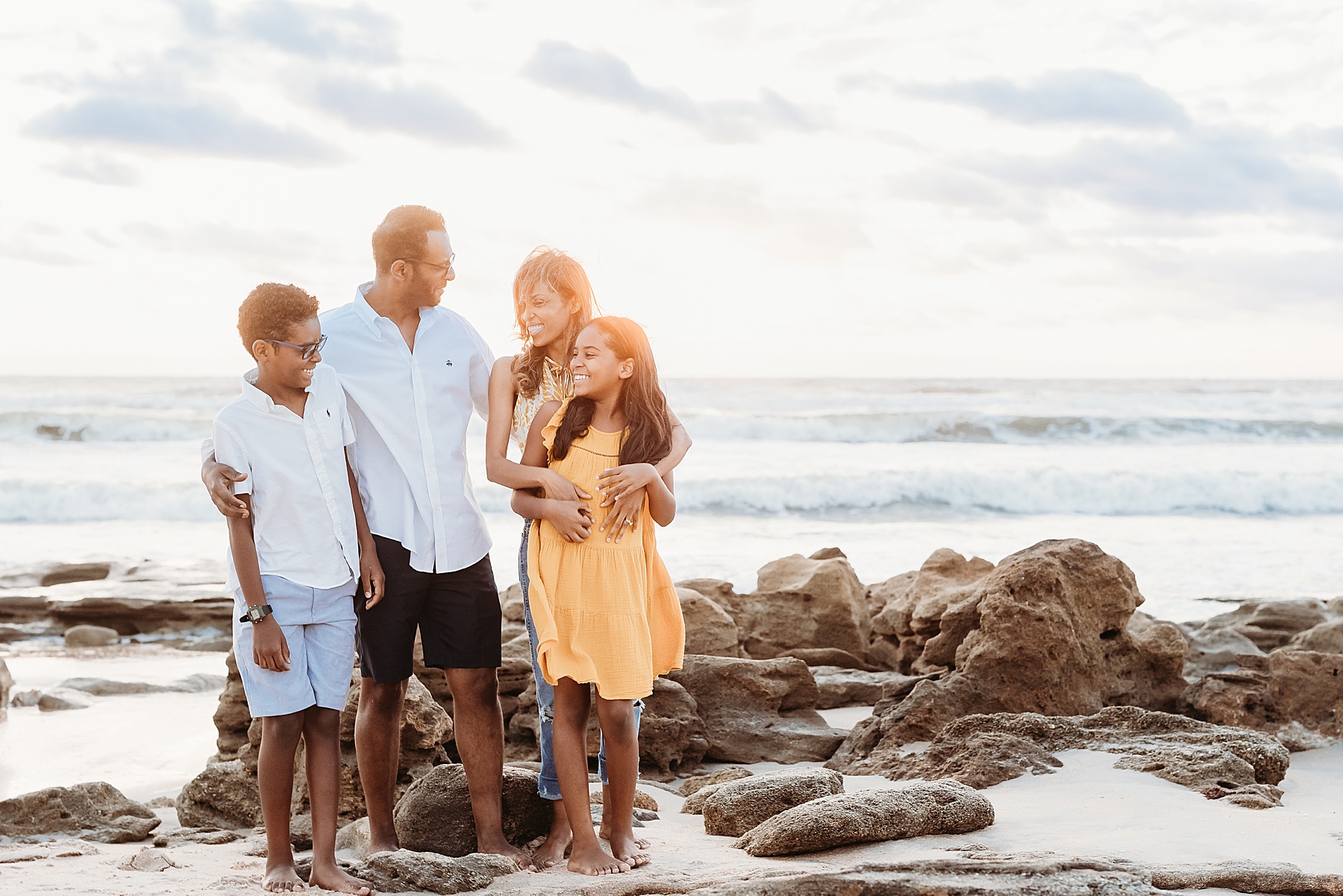 family of four standing on the rocks in st. augustine beach