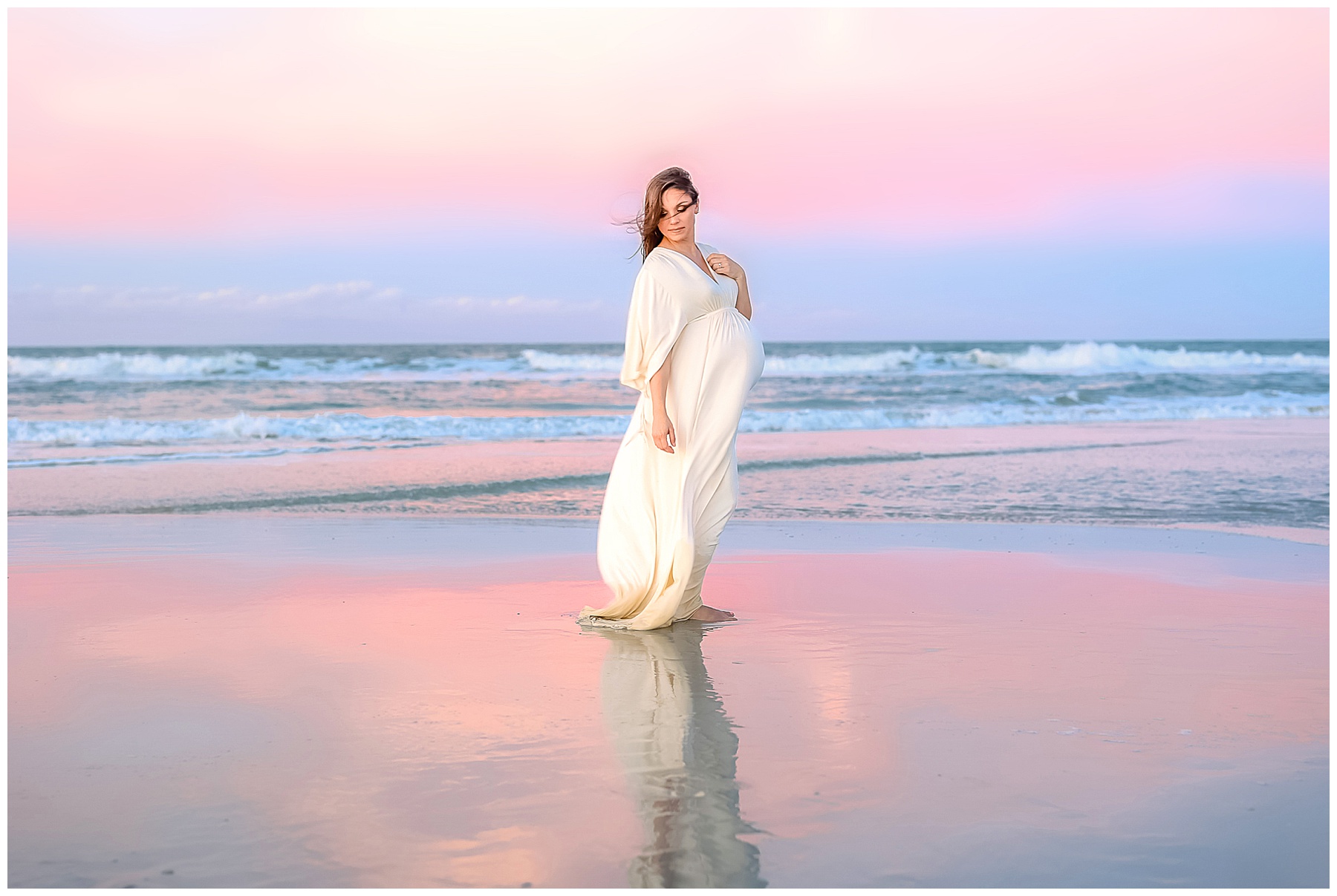 pregnant woman standing on the beach in saint augustine florida during a color pastel sunset
