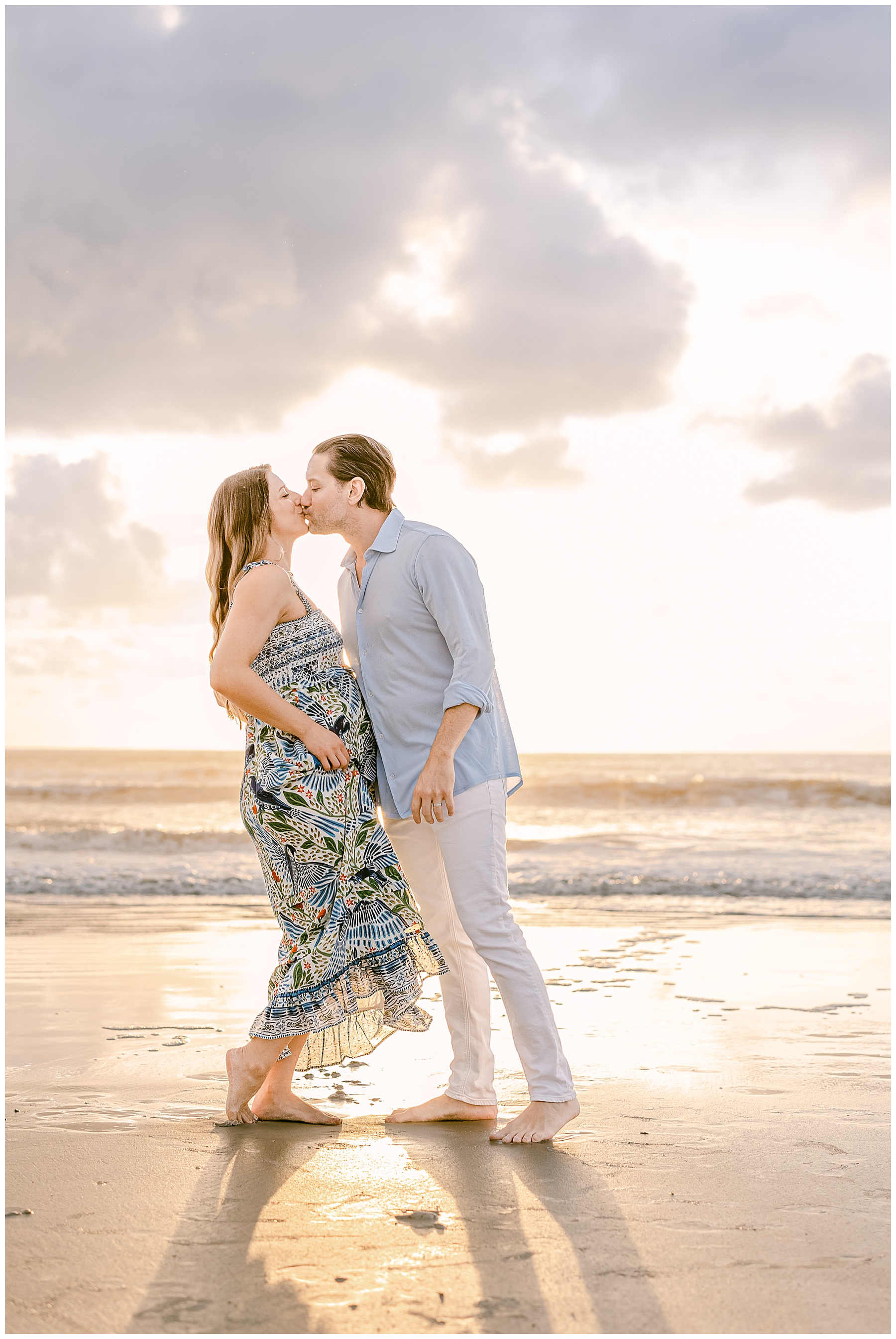 pregnant woman in long colorful dress on the beach at sunrise