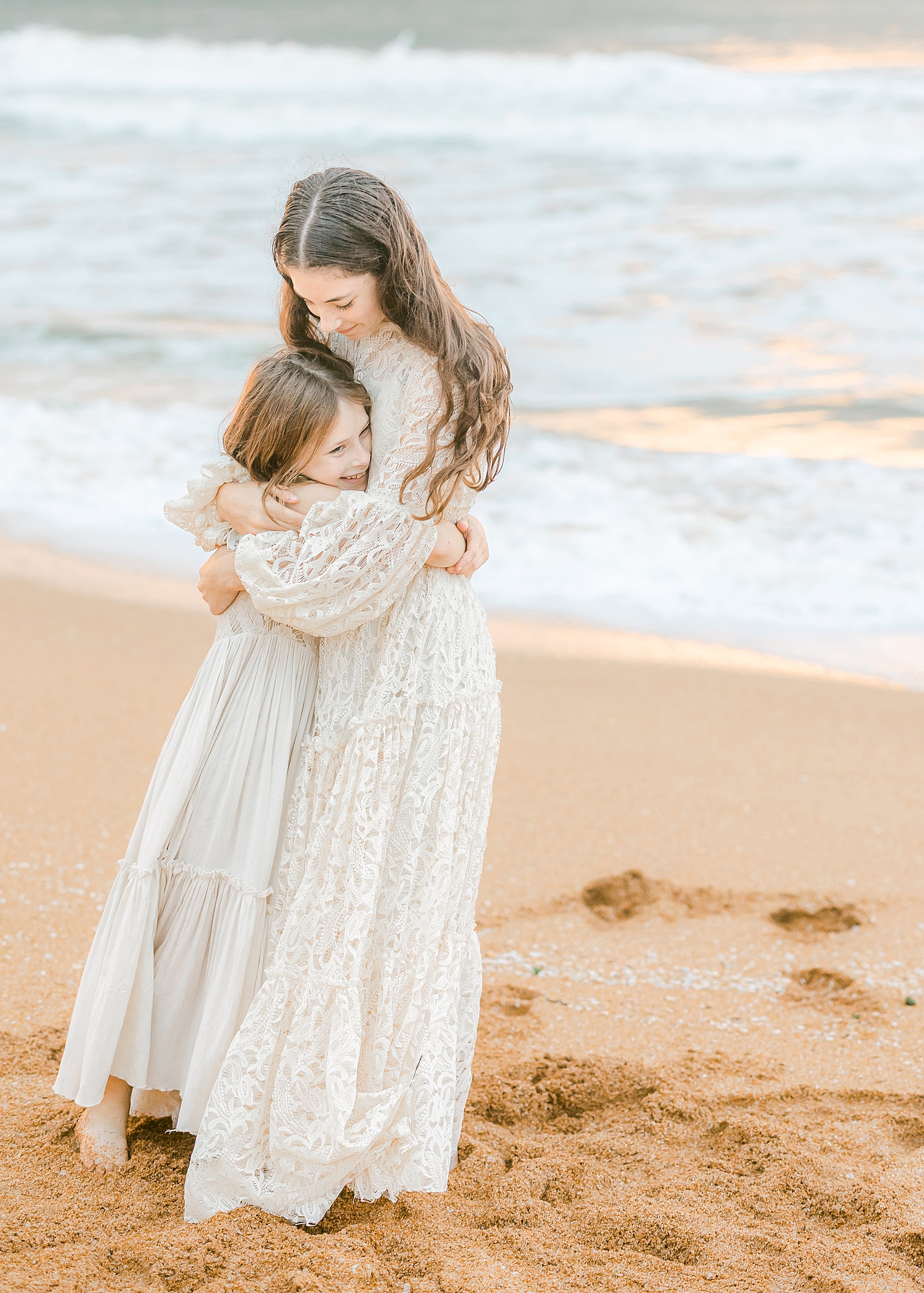 two girls in long white dresses at sunrise on the beach at flagler pier
