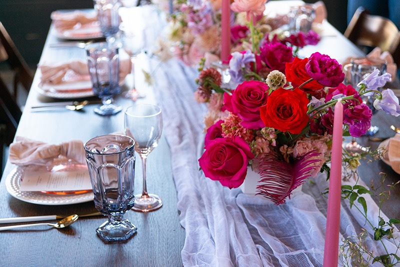 Pink flowers and table setting at a wedding.