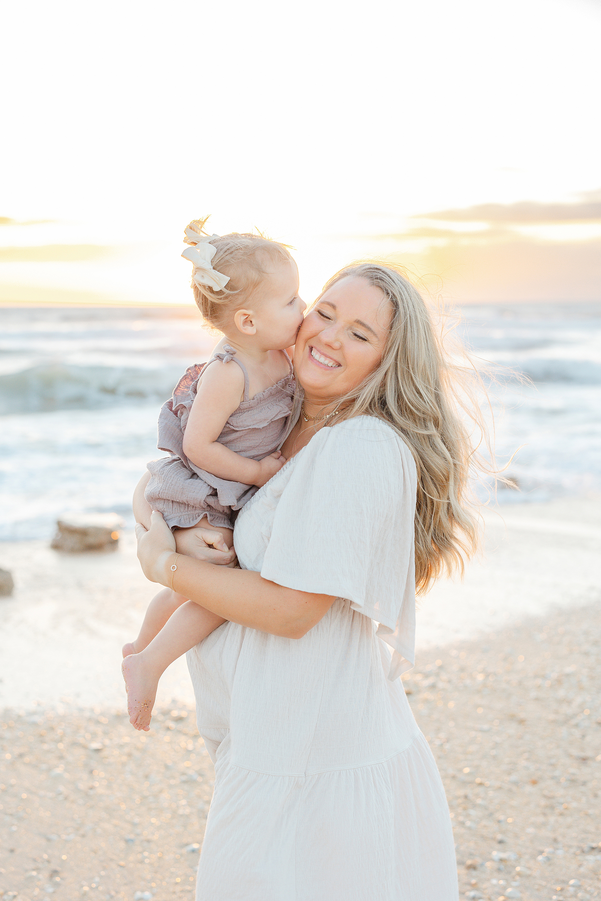 Light and airy sunrise portrait of mother with baby daughter.