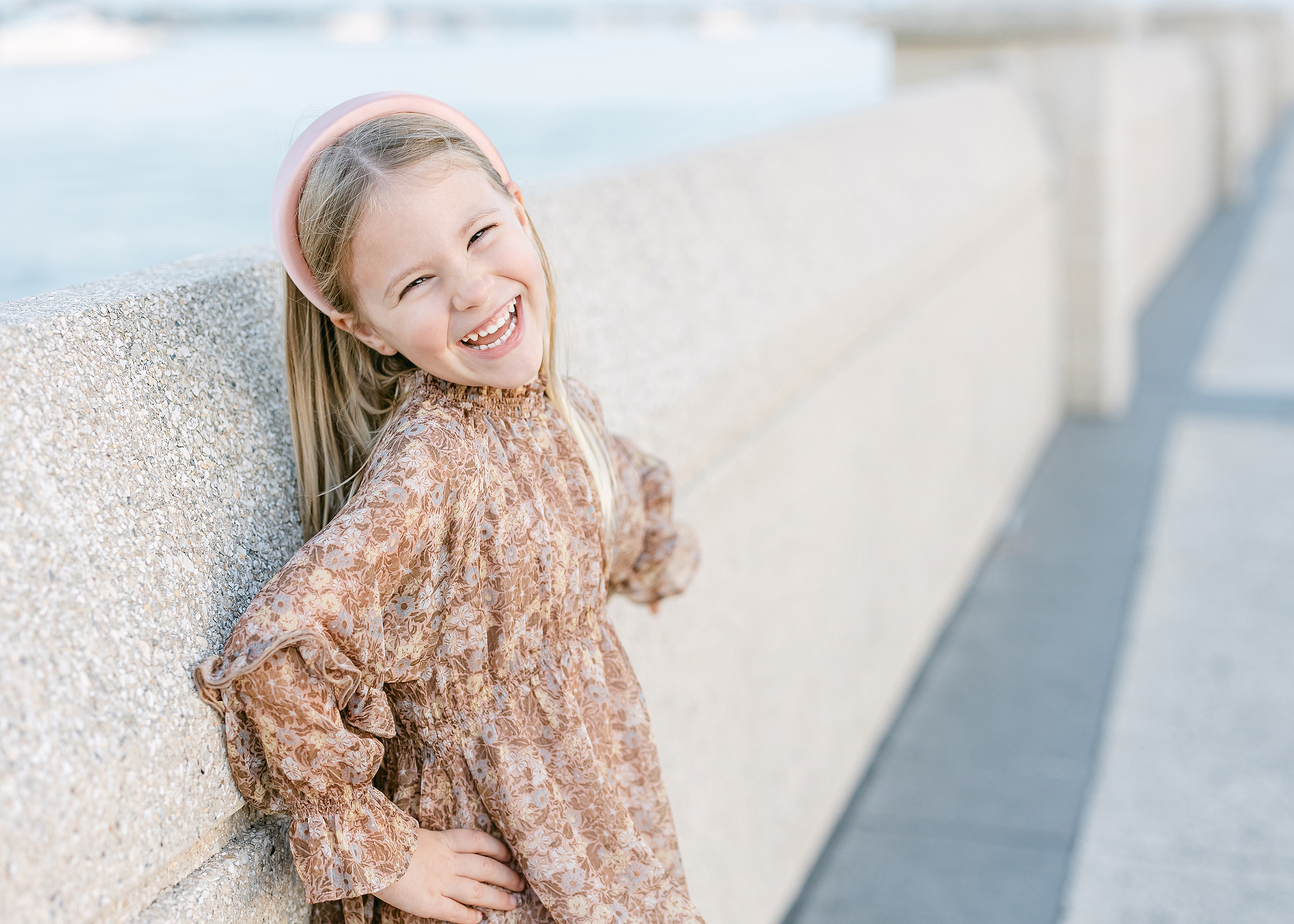 Portrait of a little girl smiling at sunset on the wharf in Saint Augustine, Florida.