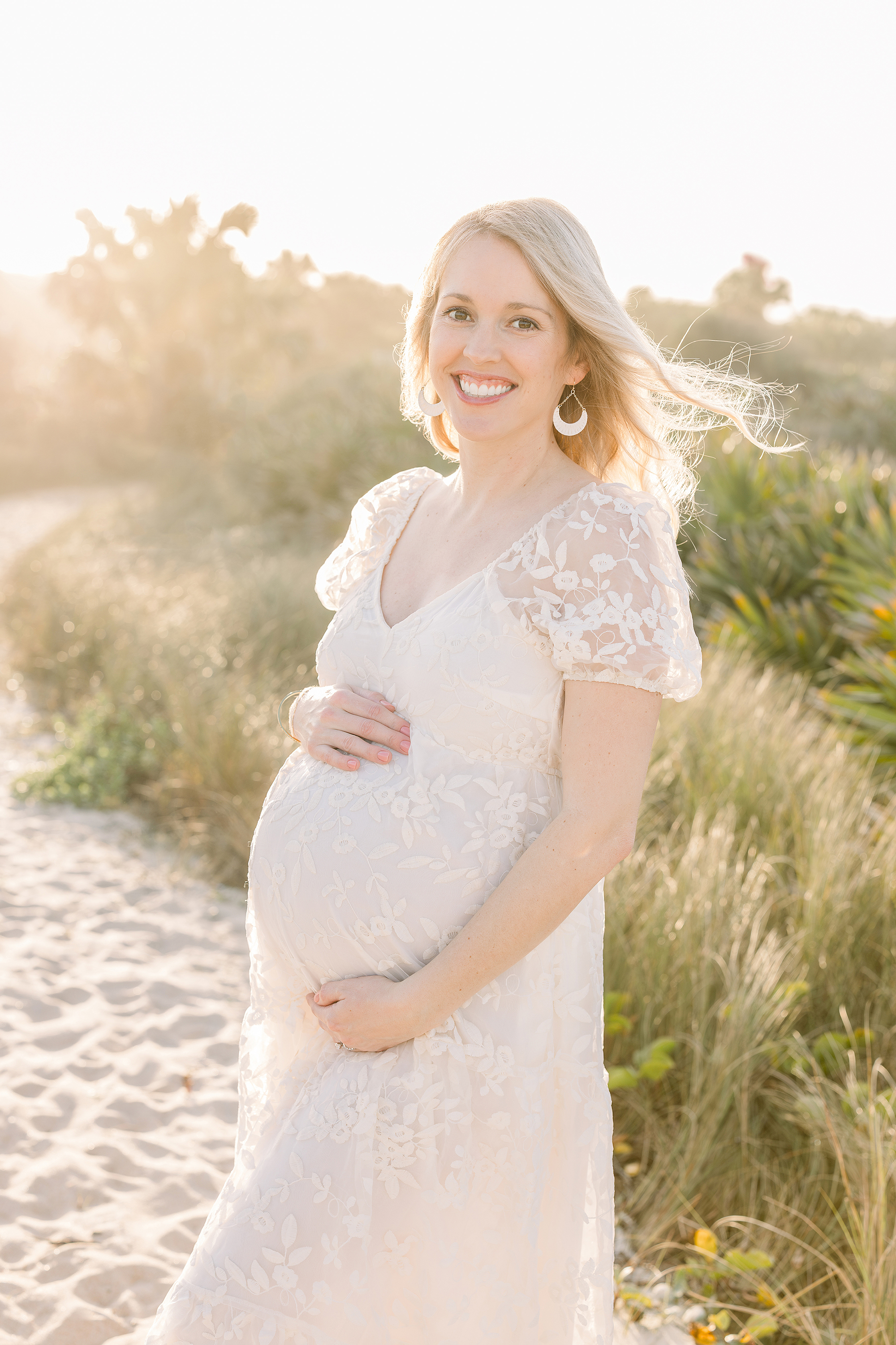 A pregnancy portrait of a woman on the beach at sunset during the Golden Hour.