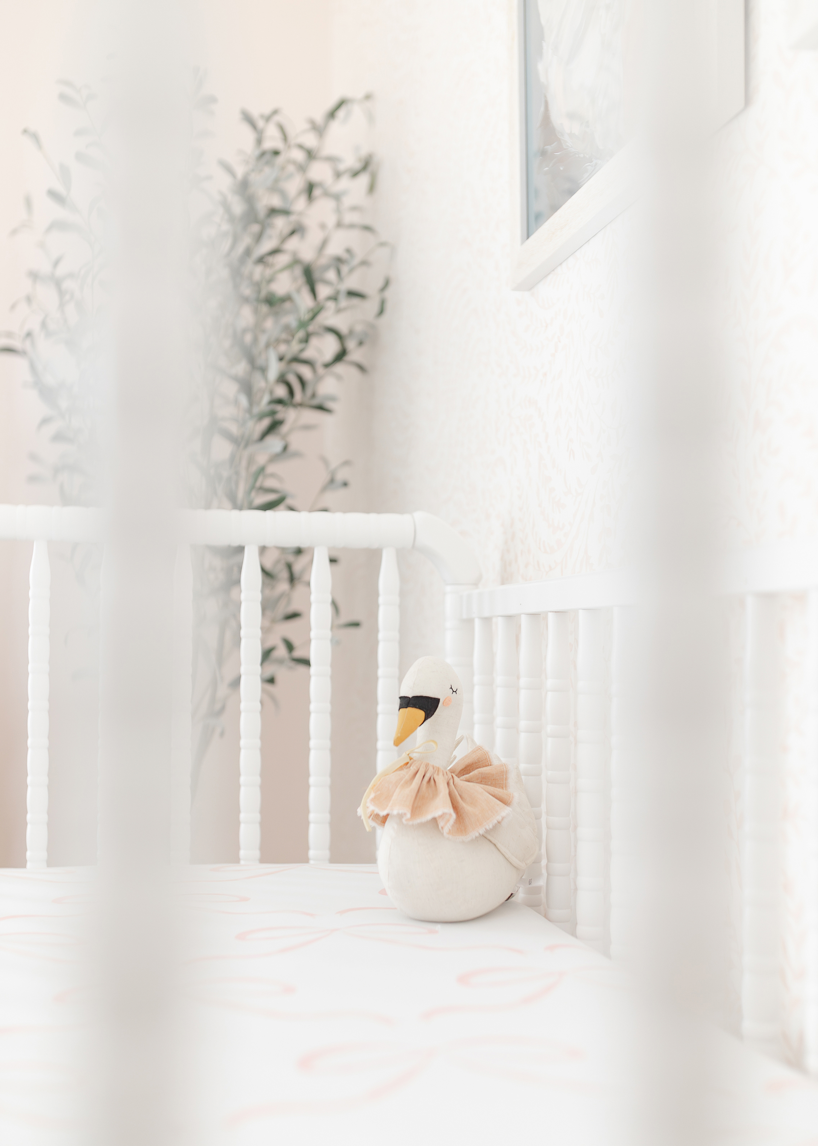 A detail image of a white and pink newborn baby girl nursery.
