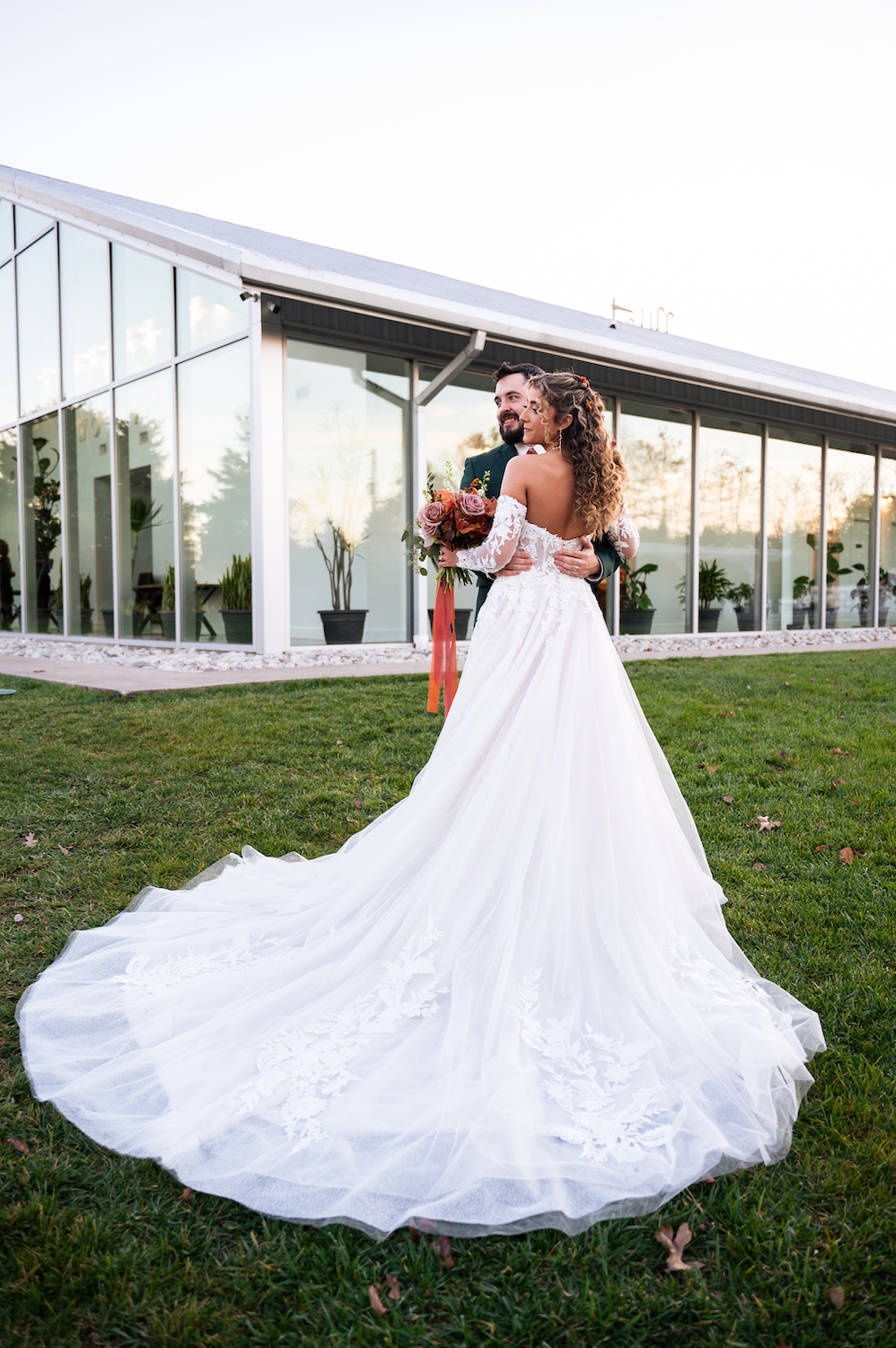 Groom in green suit and his bride embrace and smile after their wedding near Springfield, MO