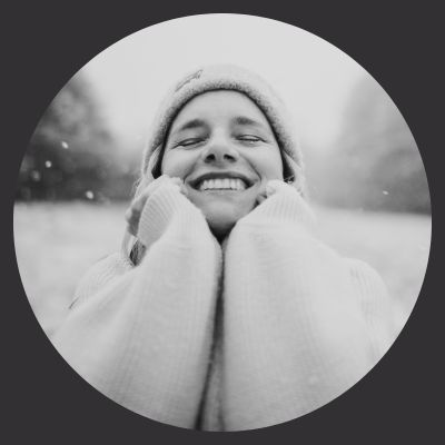 black and white picture of woman outside in snowstorm smiling