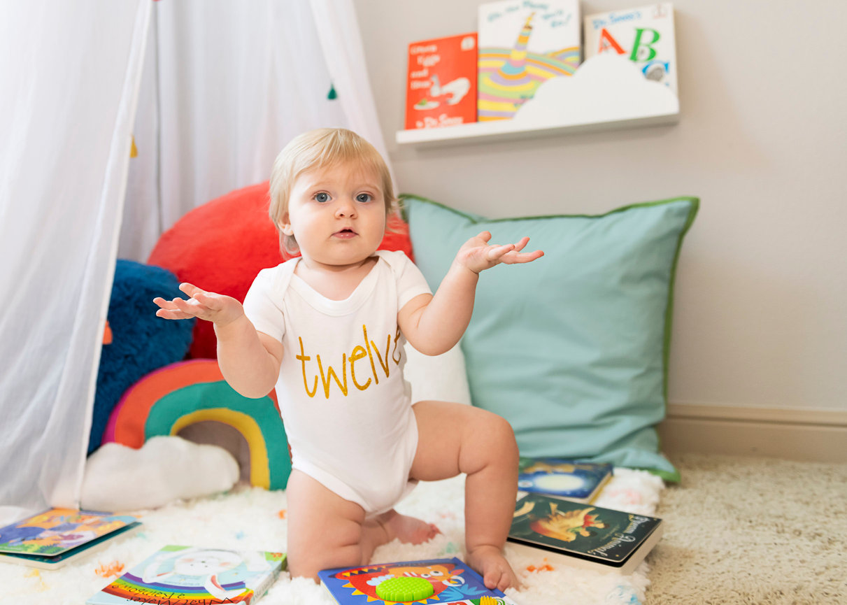 A twelve month old child in the reading corner of her room.