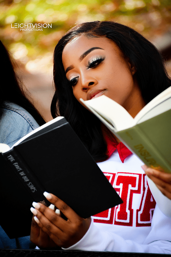 Two women on a bench, deeply focused on their books, enjoying a peaceful moment in a park.