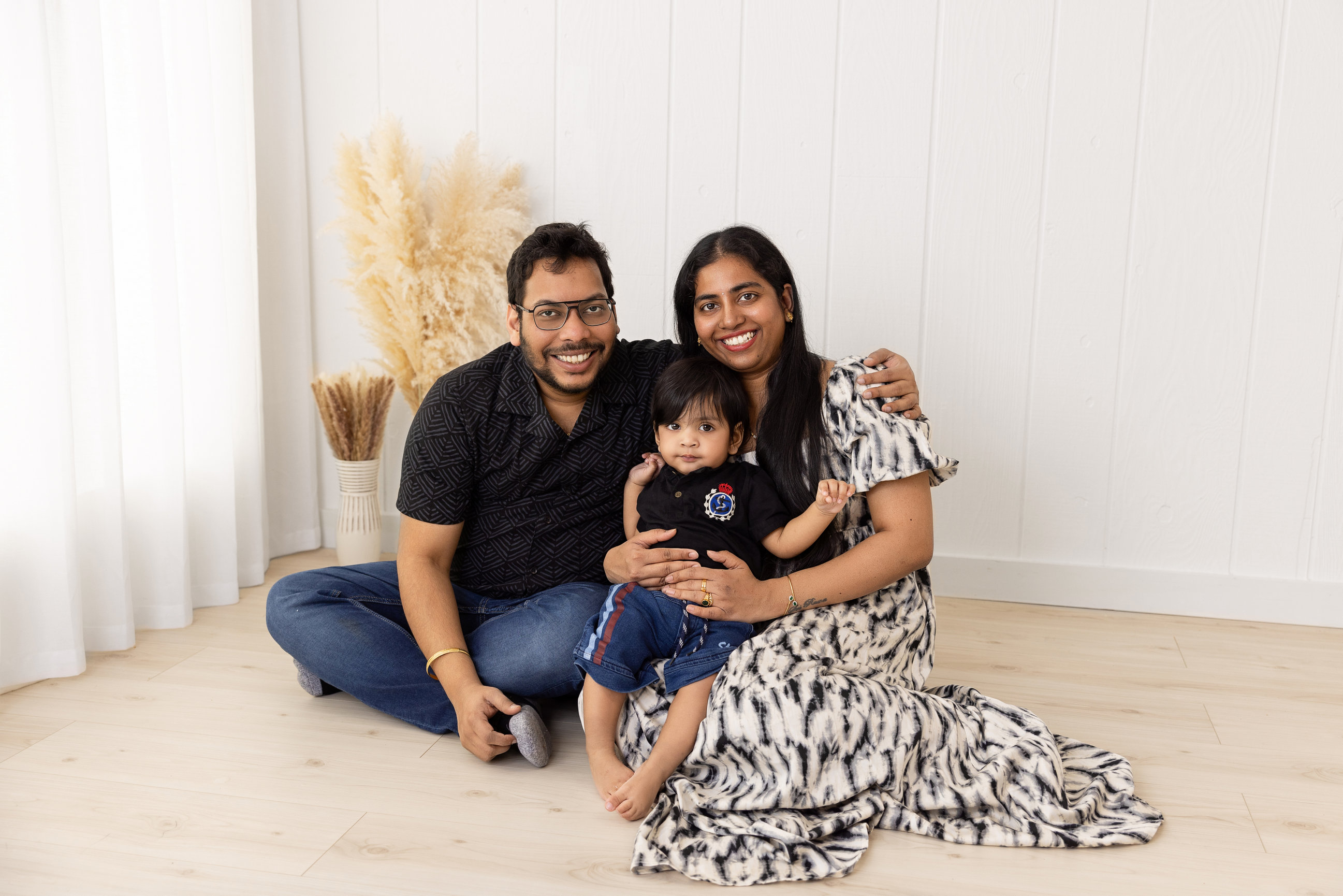 Parents and their baby together in the white studio lifestyle area
