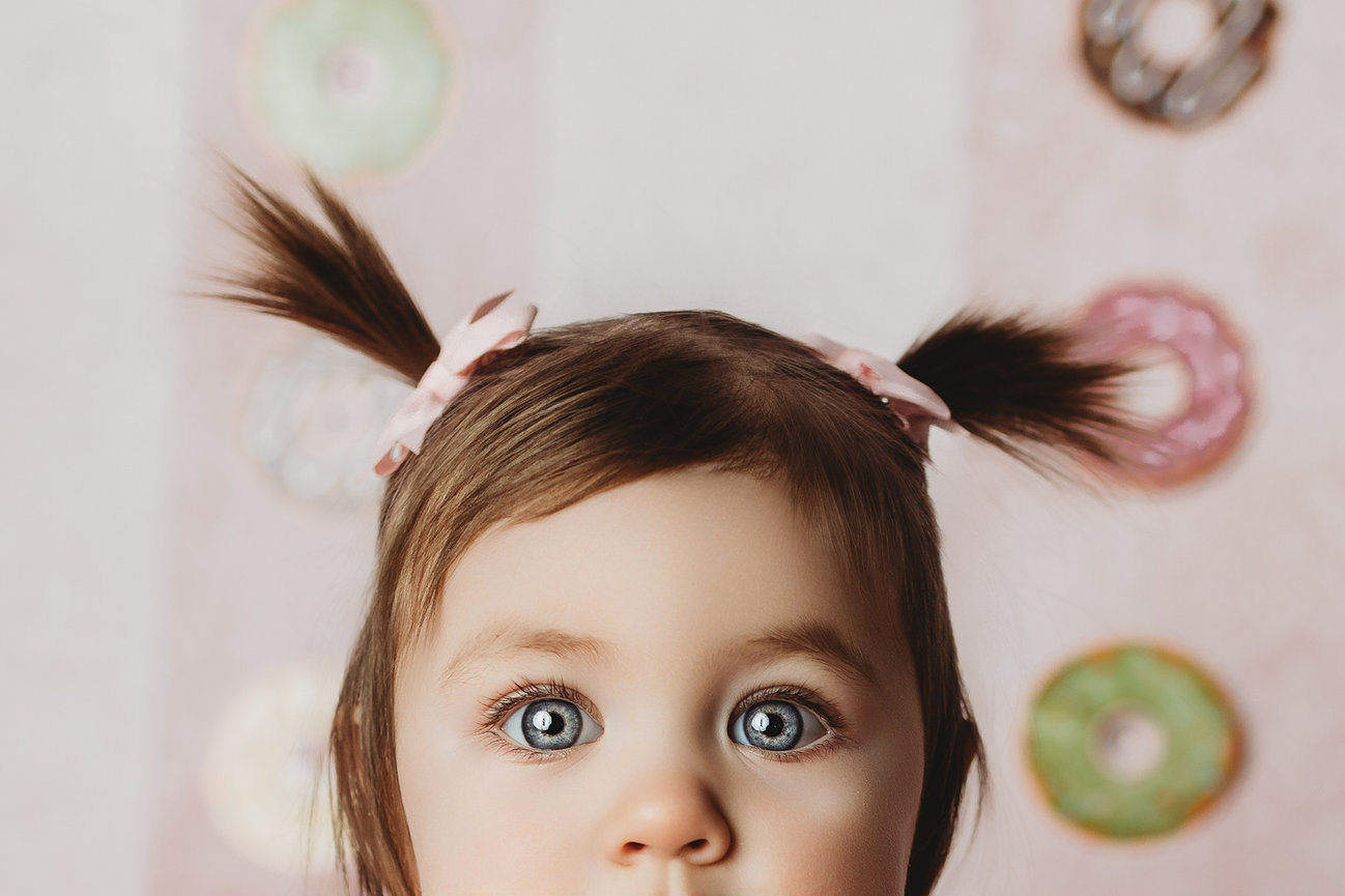 Close-up of baby's face with donuts in the background