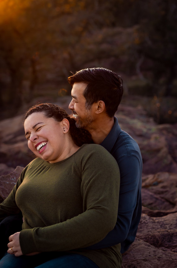 Couple laughing and embracing on granite rocks at sunset, Texas Hill Country couples session