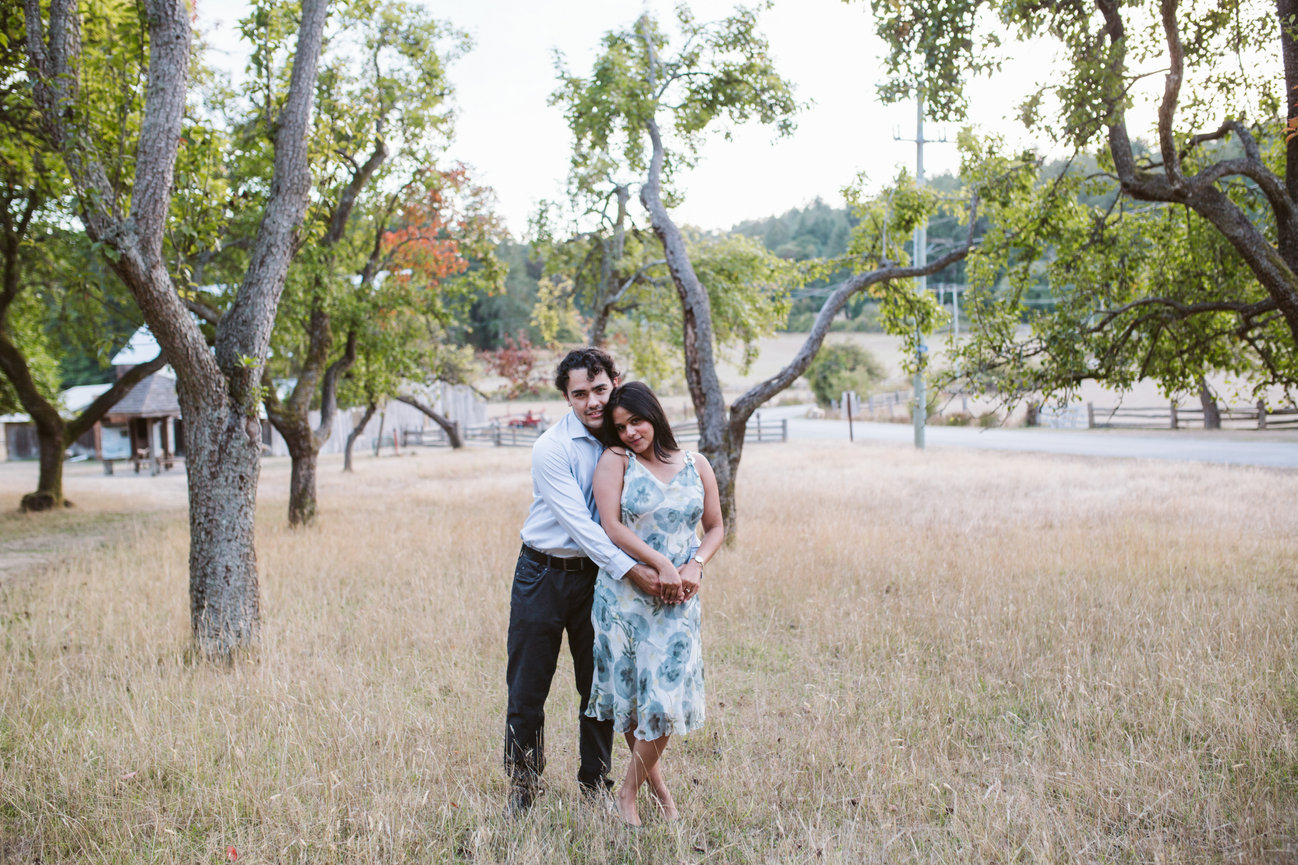 Couple embracing among orchard trees on Salt Spring Island