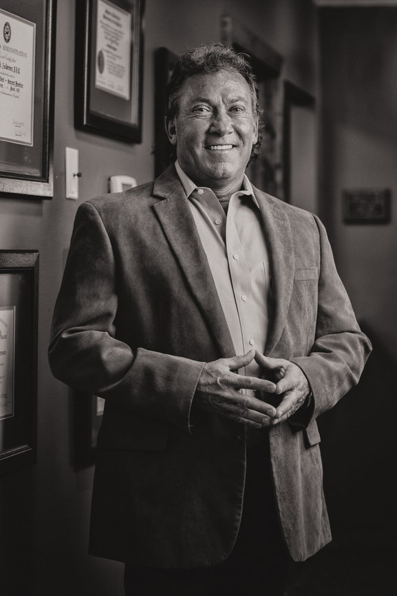 black and white business portrait of owner in the interior of his building