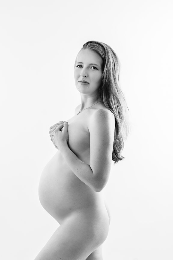 Elegant black-and-white nude pregnancy photo in minimalist Monmouth County NJ studio setting.