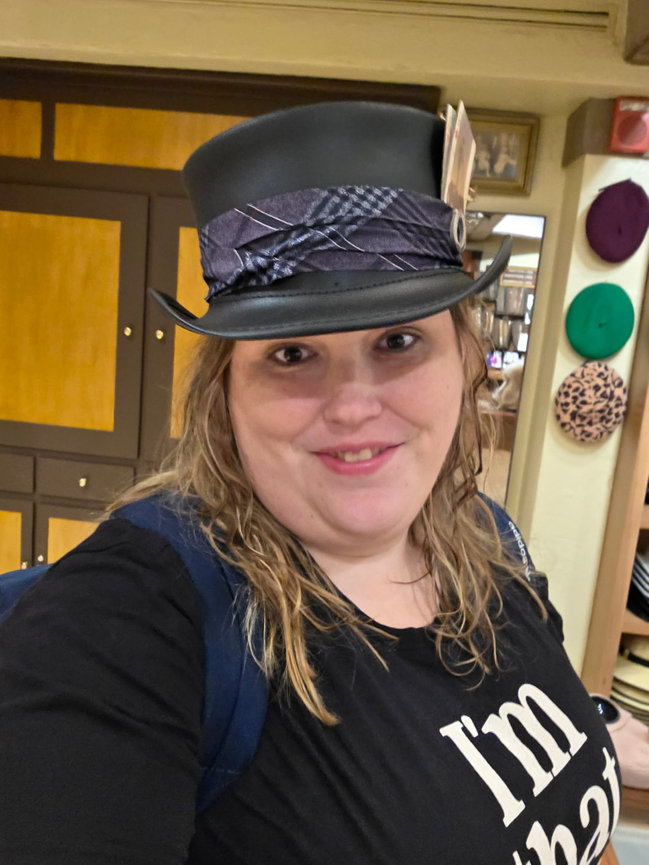 Woman in a top hat smiling indoors