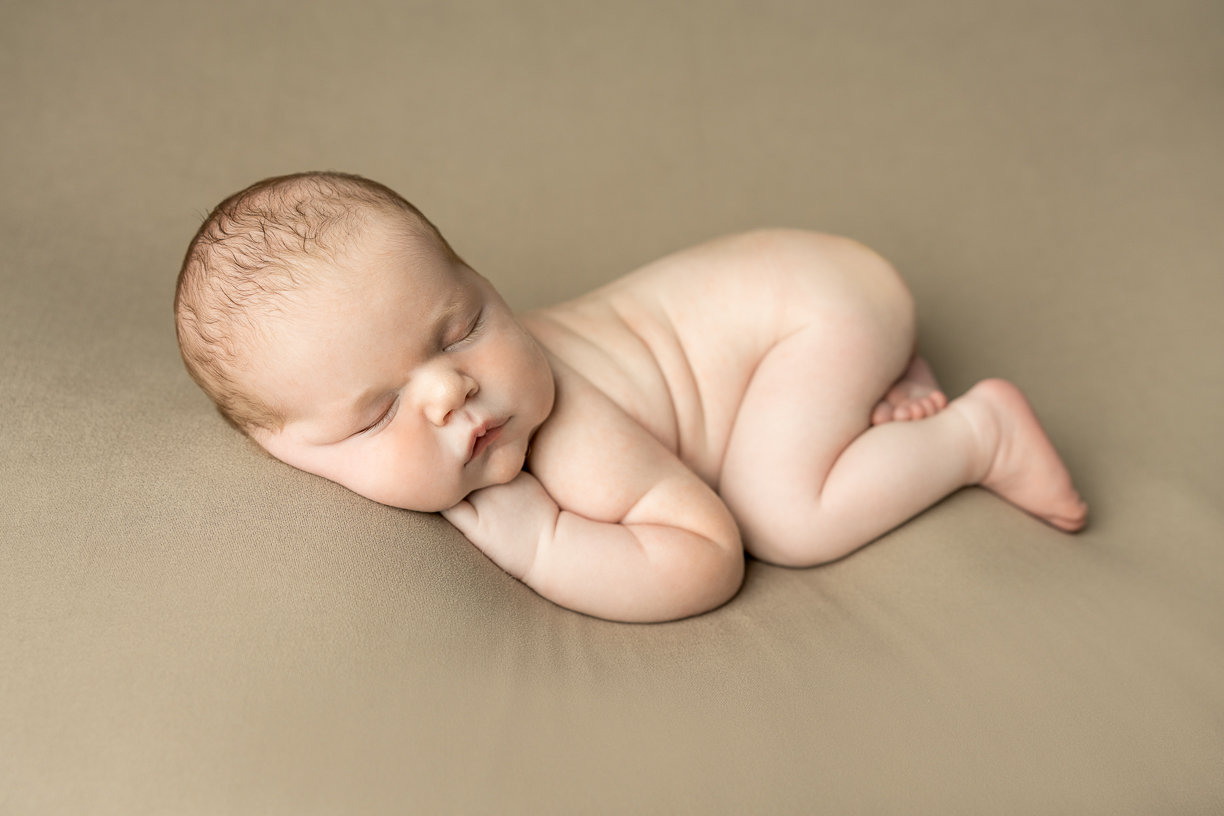 Newborn baby posed comfortably in Winnipeg Photography Studio
