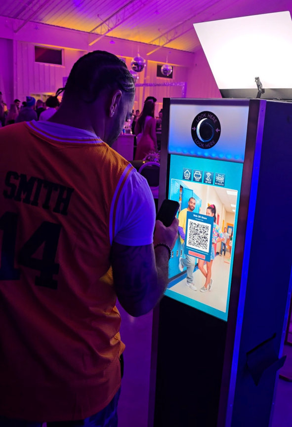 Guest interacting with the AI photo booth touchscreen to get image via QR Code