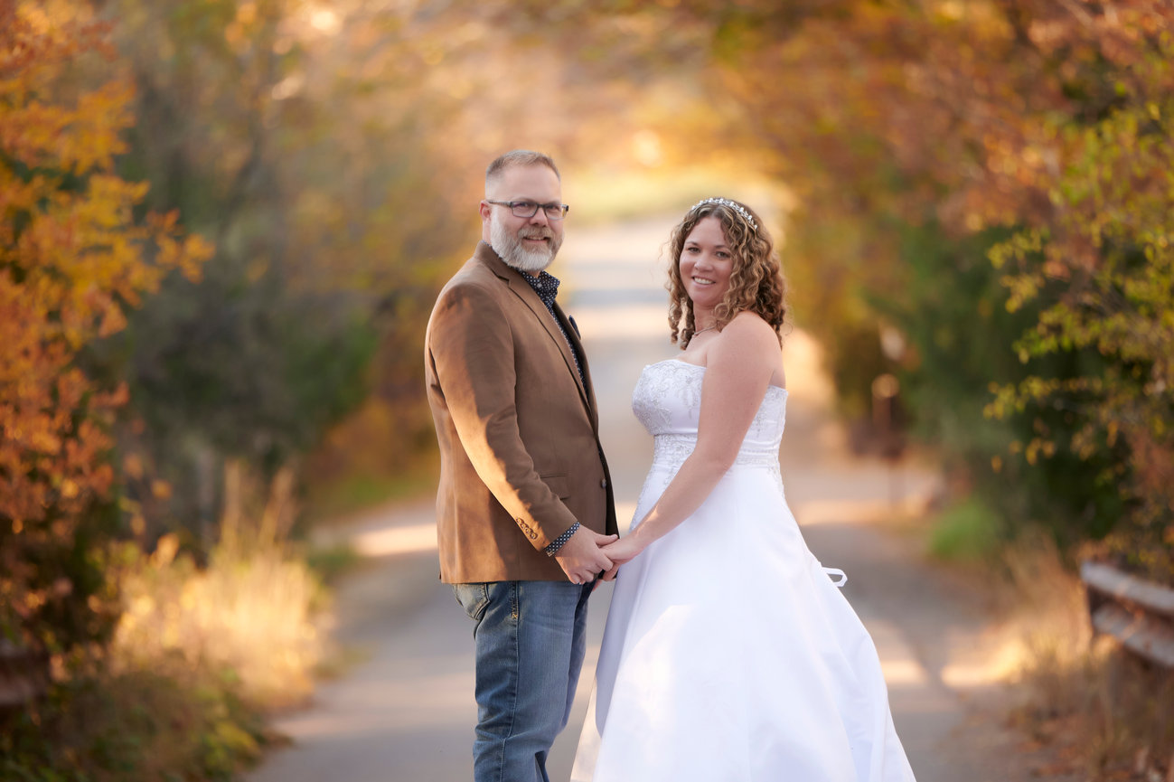 Bride and groom walking together through autumn trees in Arizona
