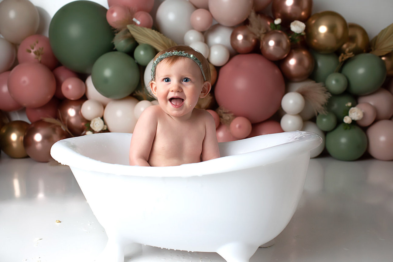 baby splashing in miniature tub after cake smash photography session with Kansas City cake smash photographer Dreamworks Photography