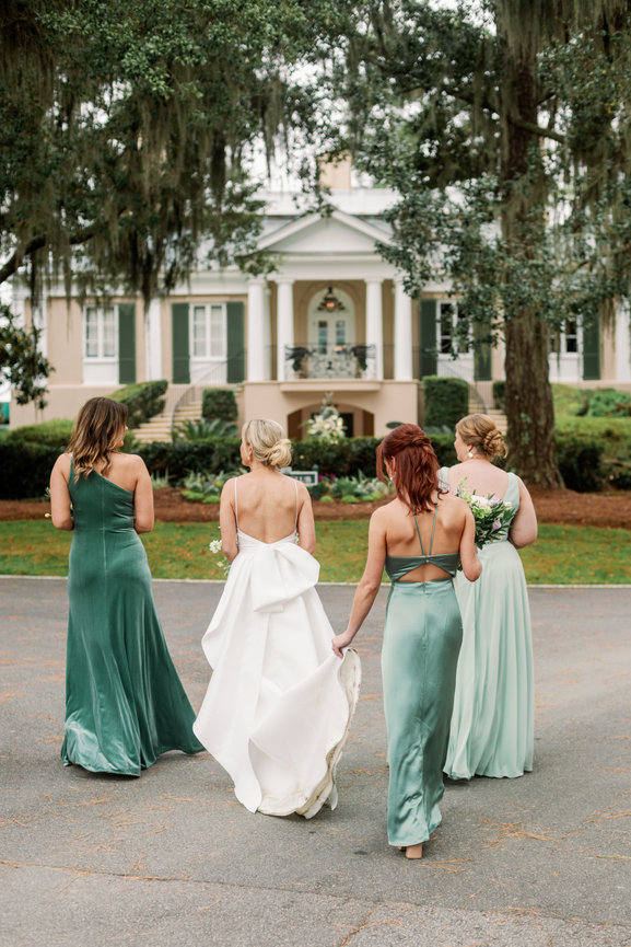 Bride and bridesmaids walking at Oldfield Club. South Carolina wedding by Heather Durham Photography.