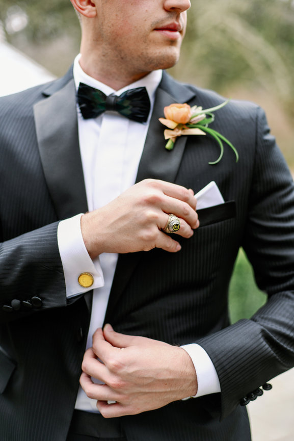 Handsome groom in custom tux and cuff links adjusting his pocket square. Destination wedding photography by Heather Durham.