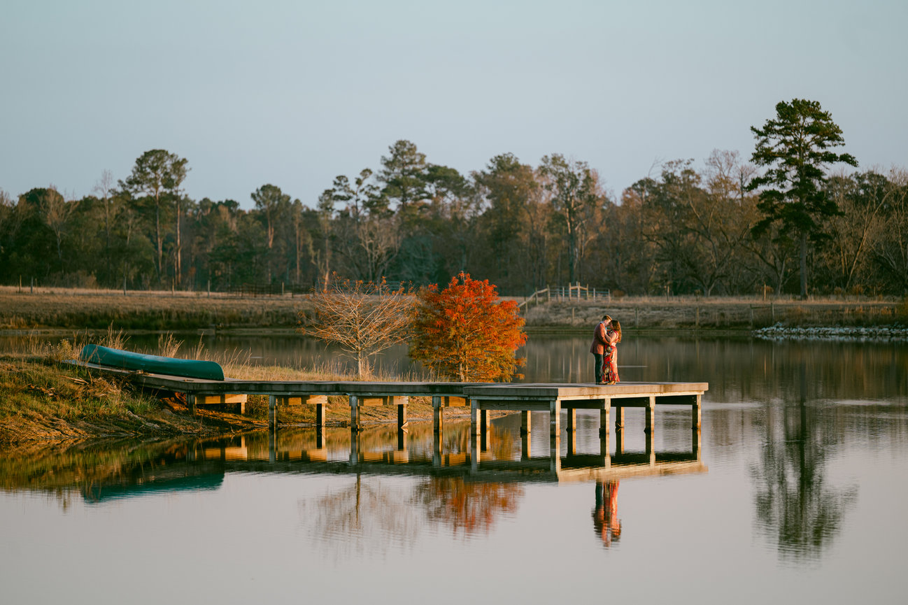 Engaged couple portrait on a dock by the lake at her family farm in Mississippi by Heather Durham Photography.