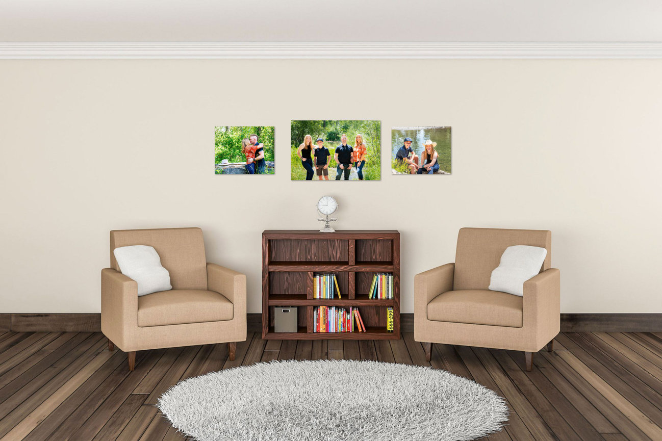 Modern living room with two beige chairs, bookshelf, round rug, and family photos on the wall