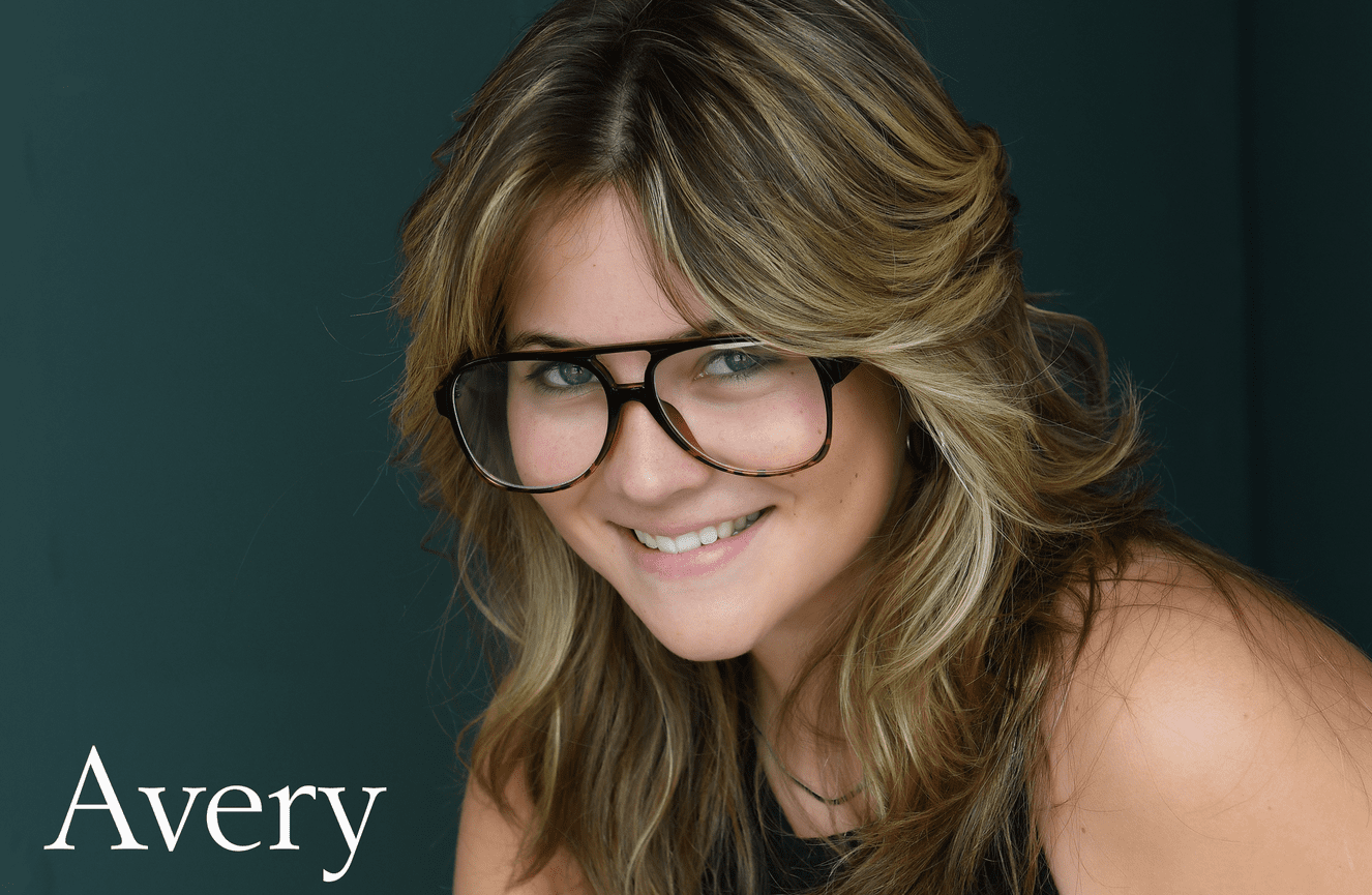 A close up portrait of a happy Avery wearing her glasses during her high school photo shoot at Kliks Photography.