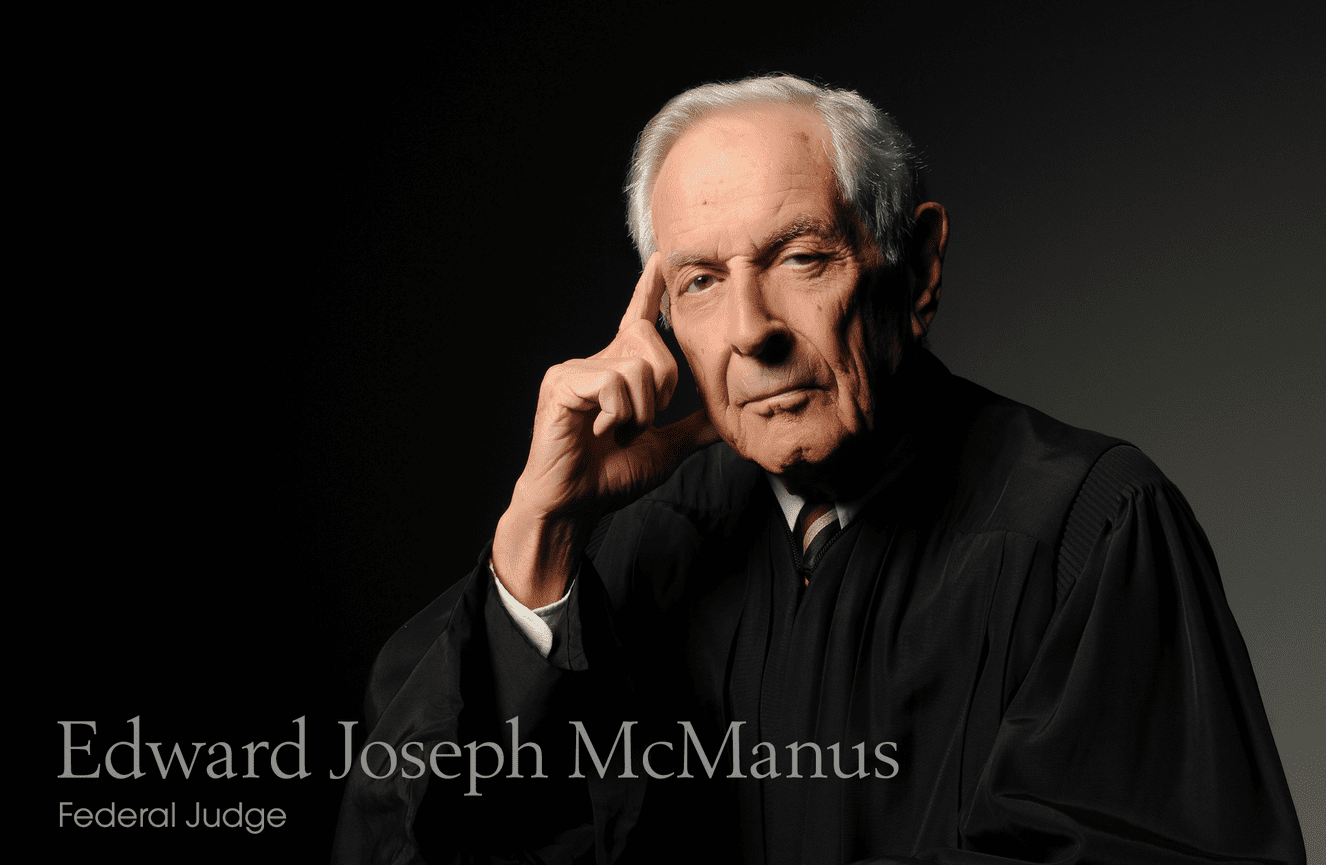 Federal Judge Edward Joseph McManus poses in his black robe for his retirement photo at Kliks Photography.