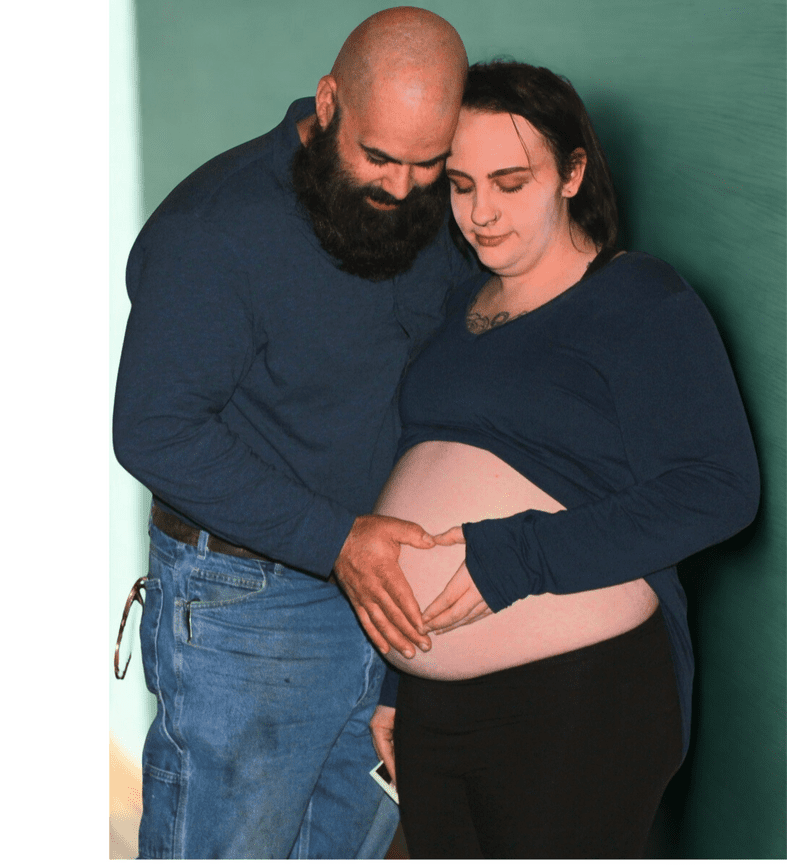 Pregnant couple embracing indoors