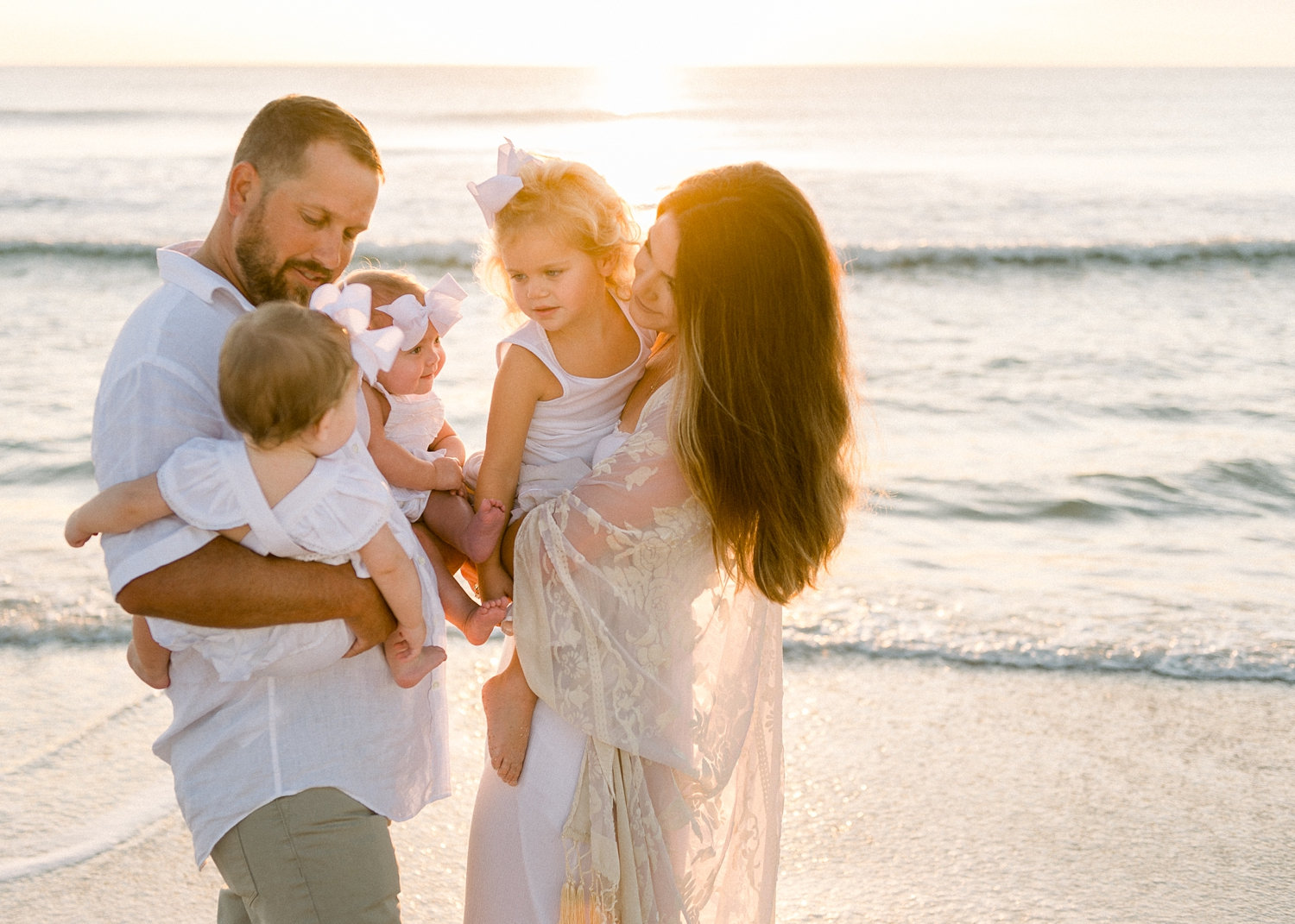 family of 5 on Ponte Vedra Beach with the sun rising over the water behind them